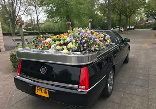 Staatsievervoer Open rouwauto met bloemen